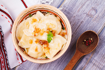Varenyky, vareniki, pierogi, pyrohy or dumplings, filled with potato and served with salty caramelized onion. View from above, top studio shot, overhead