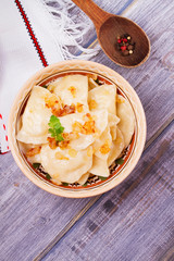 Varenyky, vareniki, pierogi, pyrohy or dumplings, filled with potato and served with salty caramelized onion. View from above, top studio shot, overhead