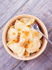 Varenyky, vareniki, pierogi, pyrohy or dumplings, filled with potato and served with salty caramelized onion. View from above, top studio shot, overhead