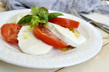 Healthy Italian Caprese Salad with Tomatoes, Mozzarella Cheese,Fresh Basils Leaves and Olive Oil
