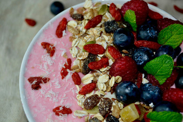 Healthy Breakfast Fresh Fruit Smoothie Bowl with Granola, Raspberries,Blueberries, Goji Berries, and Mint
