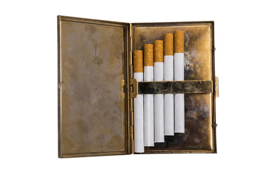 Metal vintage opened cigarette case with five cigarettes on isolated background.