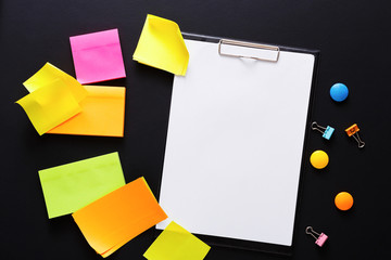 Color notes and note paper on black board, copy space
