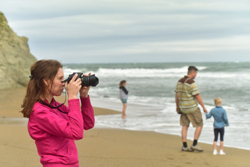 Girl photographer on the coast/ Girl photographer on the beach in the time of the shooting