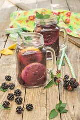Drinks made with fresh blackberries on a wooden table