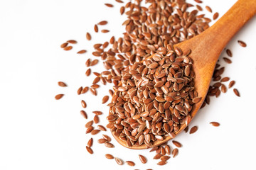 Flax seeds and spoon on white background
