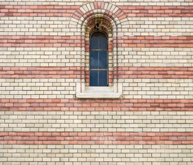 Fototapeta na wymiar Metallic window and background of two colors brick wall, with fine texture
