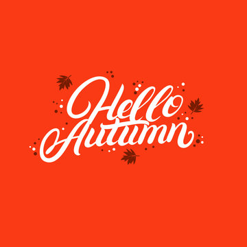 Hello autumn hand written lettering with falling yellow and orange leaves.