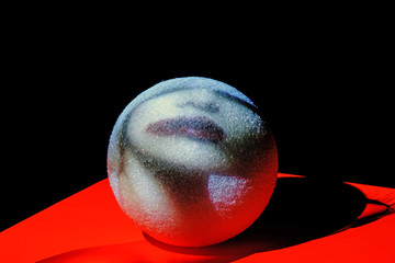A projection of a woman face on a foam sphere