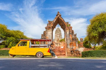 Foto op Canvas Young asian female traveler with backpack traveling sitting on taxi or Tuk Tuk and see map travel with old temple (Wat Mahathat) background, Ayutthaya Province, Thailand © Southtownboy Studio