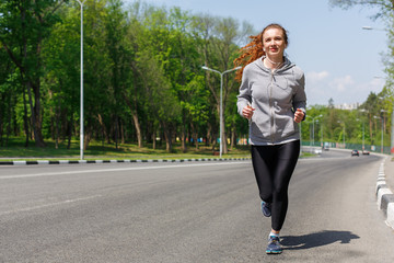 Young woman jogging on road, copy space