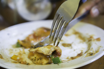 People use a fork to slice pizza in a plate.