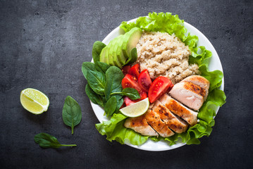 Fresh salad from quinoa, chicken breast, spinach, lettuce and tomatoes