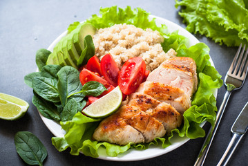 Fresh salad from quinoa, chicken breast, spinach, lettuce and tomatoes