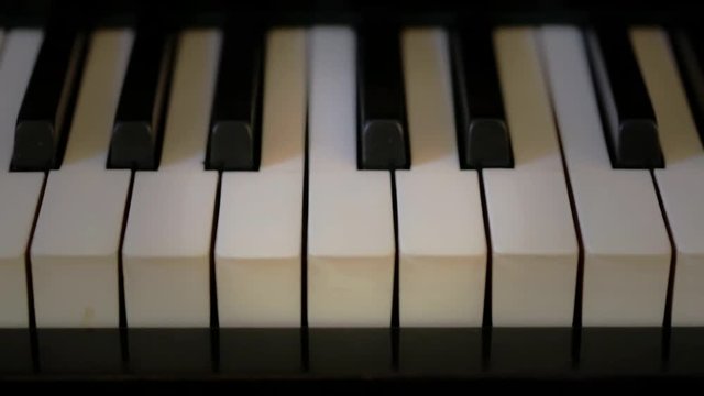 Closeup on piano keys. Camera travel from right to left.