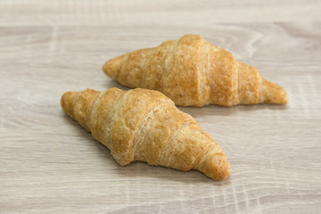 CROISSANT
Two brown croissant on the wood table. 