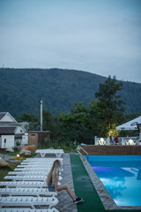 Fototapeta premium Women at pool in enjoying mountain view