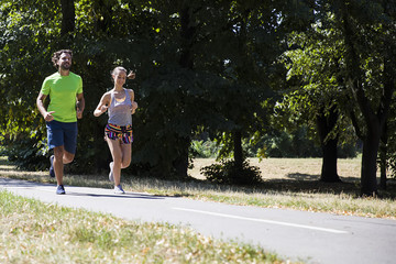 Young couple running in the park on a sunny day