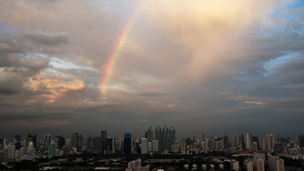 Rainbow over industrial buildings in city after rain. Bangkok city life.