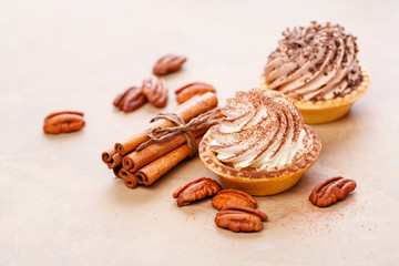 Tasty Homemade mini tarts with whipped cream pecans and cinnamon.