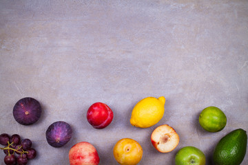 Figs, avocado, plums, apples, grapes, lemon and blackberries. View from above, top studio shot of fruit background. Flat lay setup made of selection of healthy food, copy space, overhead
