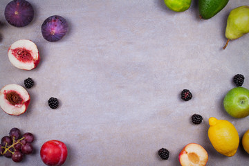 Figs, avocado, plums, apples, grapes, lemon and blackberries. View from above, top studio shot of fruit background. Flat lay setup made of selection of healthy food, copy space, overhead