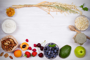 Yogurt, Oat Flakes, Fruits, Honey and Summer Berries. View from above, top studio shot of fruit background. Flat lay setup made of selection of healthy food, copy space, overhead
