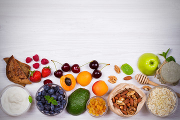 Yogurt, Oat Flakes, Fruits, Honey and Summer Berries. View from above, top studio shot of fruit background. Flat lay setup made of selection of healthy food, copy space, overhead
