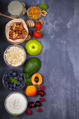 Obraz na płótnie Canvas Yogurt, Oat Flakes, Fruits, Honey and Summer Berries. View from above, top studio shot of fruit background. Flat lay setup made of selection of healthy food, copy space, overhead