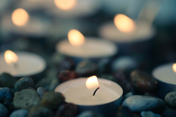 tea-light candles on pebbles stones selective focus
