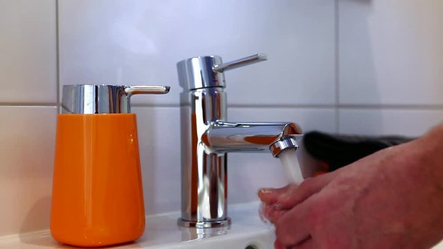 Washing hands in modern bathroom
