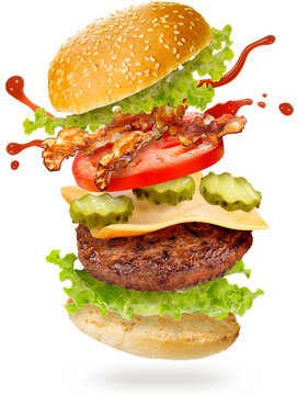 flying layers of bacon cheeseburger on white background