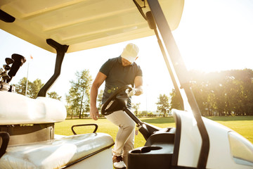 Male golfer getting in a golf cart