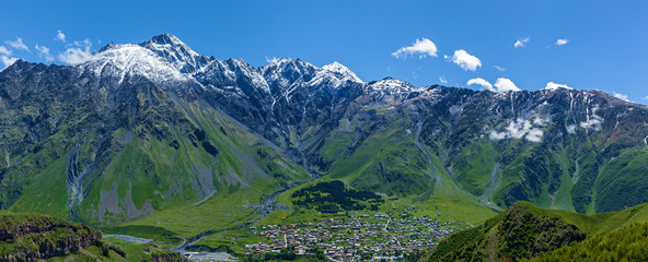 Naklejka na ściany i meble Village under the mountains of Kazbegi, Stepancminda,Sight of Georgia
