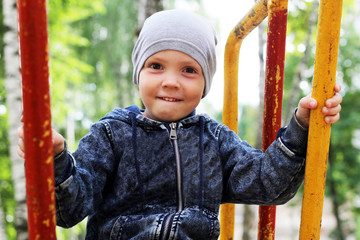 Portrait of little boy on nature background among birches