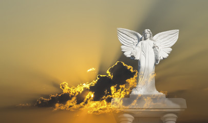 Weiße Engelsfigur auf Sockel mit golden strahlendem Himmel und Wolken, Symbolbild für Überirdisch, Hoffnung, Reinheit
