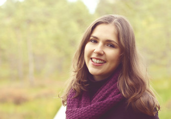 Close-up portrait of a young, beautiful and happy woman in forest. Camp, adventure, trip, hiking concept.