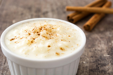 Arroz con leche. Rice pudding with cinnamon on wooden background
