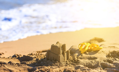 sand castle and baby hazel sandals on the seashore