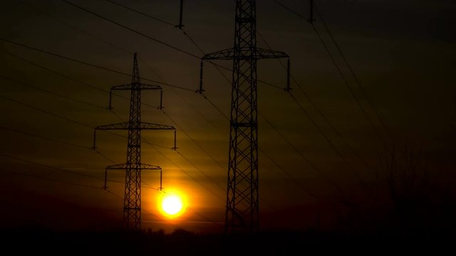Sunrise on a background of a high-voltage line. Time lapse.