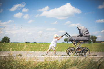  Little brothers on a summer day with a stroller