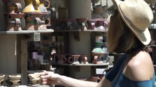Young, beautiful woman checking souvenirs on flea market in Oman
