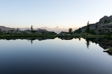 Fototapeta premium Mountain lake reflection at dawn in summer outdoor.