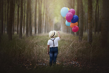 niño con globos en el bosque