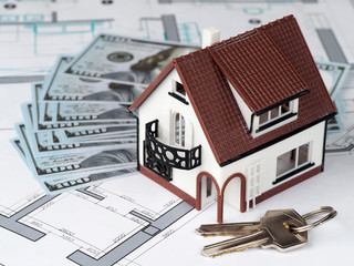 Toy house and keys on building plan