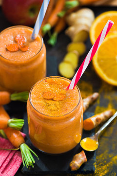 Fresh smoothie with carrot, apple, orange, banana, ginger and turmeric root