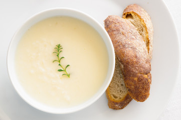 chicken soup with lemon, egg, and rice decorated with thyme and rye bread