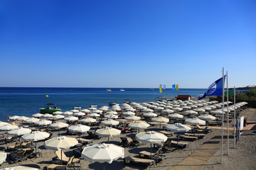 Parasole i leżaki na plaży wzdłuż morza Śródziemnego. - obrazy, fototapety, plakaty