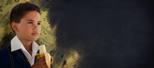 Composite image of schoolboy looking away while eating banana