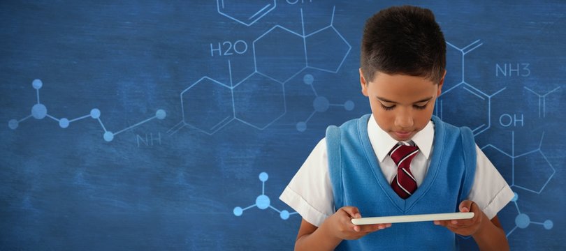 Composite image of schoolboy using digital tablet